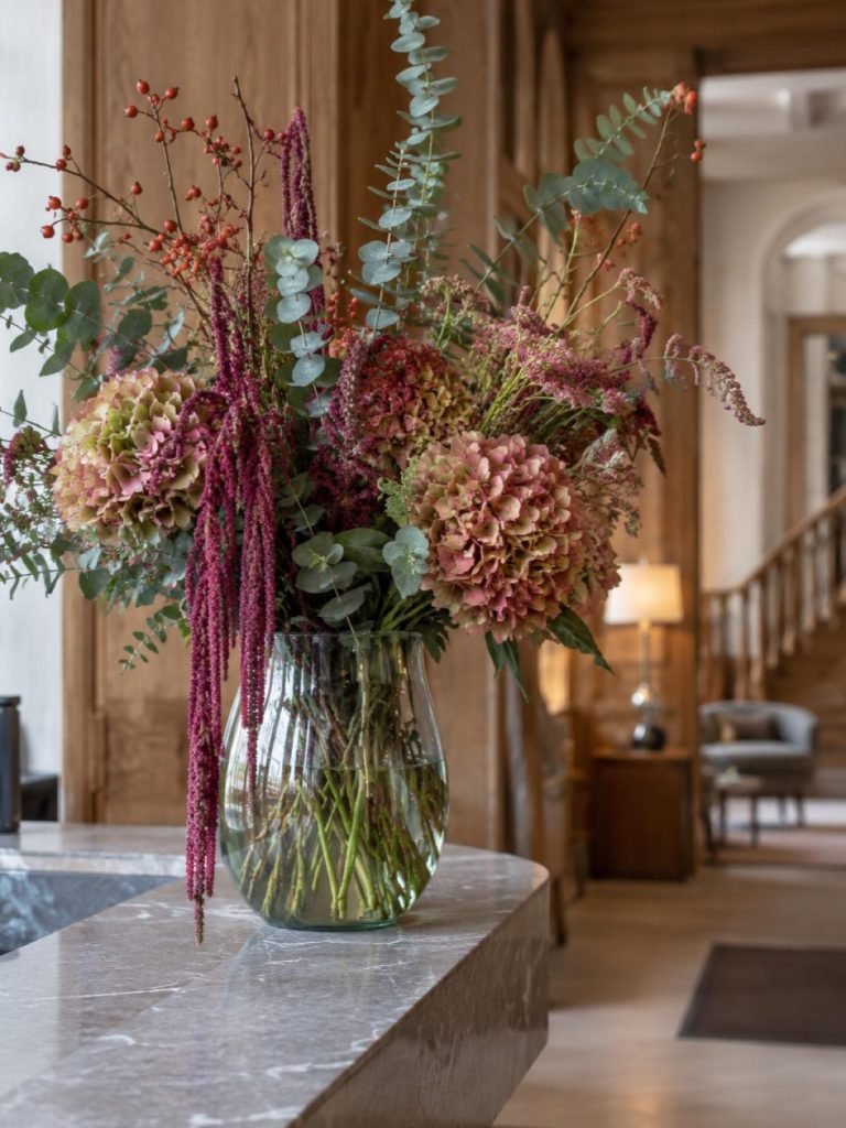 Grote vaas met herfstbloemen op een hotelbalie